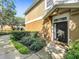 Close up of home's entrance featuring a dark front door, decorative window, and manicured shrubs at 725 Ashworth Overlook Dr # C, Apopka, FL 32712