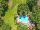 Aerial view of neighborhood pool with lounge chairs and verdant landscaping at 725 Ashworth Overlook Dr # C, Apopka, FL 32712