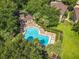Aerial view of a community pool surrounded by trees, lounge chairs, and a pool house at 725 Ashworth Overlook Dr # C, Apopka, FL 32712