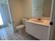 Simple bathroom features white vanity, toilet and tiled floor at 8012 Old Town Dr, Orlando, FL 32819