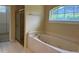 Bright bathroom features a shower, garden tub, and a large sunny window at 8012 Old Town Dr, Orlando, FL 32819