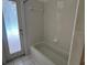 Bathroom with basic tub, shower and patterned glass door to outside at 8012 Old Town Dr, Orlando, FL 32819