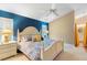 Inviting bedroom with bright blue accent wall, comfortable white furniture and bedding at 849 Bentley Green Cir, Winter Springs, FL 32708