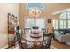 Charming dining area featuring a decorative chandelier, round table, and ample natural light from a large window at 849 Bentley Green Cir, Winter Springs, FL 32708
