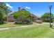 Charming brick home featuring a well-manicured lawn, mature tree, and inviting walkway at 849 Bentley Green Cir, Winter Springs, FL 32708