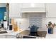 Close-up of renovated kitchen featuring white cabinetry, tile backsplash, and stainless steel appliances at 849 Bentley Green Cir, Winter Springs, FL 32708