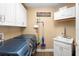 Convenient laundry room with updated appliances, wash sink, and storage cabinets above at 849 Bentley Green Cir, Winter Springs, FL 32708