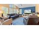 Living room with bright blue accent wall, large windows and shutters, and comfortable furniture at 849 Bentley Green Cir, Winter Springs, FL 32708
