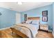 Light blue bedroom with light colored wooden floors, bed, and coordinating nightstand with a wooden frame at 901 E Pine St # 2, Orlando, FL 32801