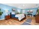 Bedroom with hardwood floors, large bed, accent furniture, and light blue walls at 901 E Pine St # 2, Orlando, FL 32801