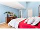 Bedroom with vaulted ceiling, wooden floors, a red bed, and wooden dresser with plant decor at 901 E Pine St # 2, Orlando, FL 32801