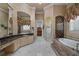 Elegant bathroom featuring a soaking tub, walk-in shower, vanity, and decorative lighting at 9142 Southern Breeze Dr, Orlando, FL 32836