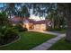 Inviting home with mature landscaping, lush lawn, and a three-car garage at sunset at 9142 Southern Breeze Dr, Orlando, FL 32836