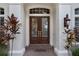Close-up of a sophisticated entryway with a double glass front door and sidelights at 9142 Southern Breeze Dr, Orlando, FL 32836