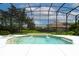 Screened-in pool with two small waterfalls and an attached spa, with a neighboring house visible through the screen at 9142 Southern Breeze Dr, Orlando, FL 32836