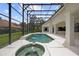 Screened-in pool with a connected spa and two waterfalls, with patio columns on the right side of the screen at 9142 Southern Breeze Dr, Orlando, FL 32836