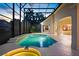 Pool and connected spa lit up at dusk, within a screened-in patio, with a neighboring house visible through the screen at 9142 Southern Breeze Dr, Orlando, FL 32836