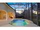 Screened-in pool with a connected spa, waterfalls, and an outdoor kitchen visible to the left, lit up at dusk at 9142 Southern Breeze Dr, Orlando, FL 32836