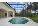 Backyard with a screened-in pool, attached spa, two waterfalls, and a patio area with an outdoor kitchen at 9142 Southern Breeze Dr, Orlando, FL 32836