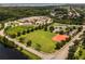 Aerial view showcases neighborhood amenities, including a playground, tennis courts, and fields at 9319 Marsh Oaks Ct, Orlando, FL 32832