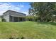 Expansive backyard featuring lush lawn, mature trees, and screened lanai, perfect for outdoor living at 9319 Marsh Oaks Ct, Orlando, FL 32832