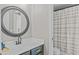 Bathroom featuring a modern vanity, round mirror and shower with striped curtain at 9319 Marsh Oaks Ct, Orlando, FL 32832
