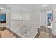 Second-floor hallway with hardwood flooring, elegant lighting, and stairway at 9319 Marsh Oaks Ct, Orlando, FL 32832