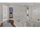 Second-floor hallway with open view to a bedroom and classic white staircase at 9319 Marsh Oaks Ct, Orlando, FL 32832