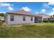 View of the home's back exterior, screen patio, and lawn space under a blue sky at 10151 Chorlton Cir, Orlando, FL 32832