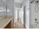 Bathroom featuring tile flooring, vanity sink, toilet, and shower, with hall view at 10151 Chorlton Cir, Orlando, FL 32832