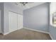 Bedroom features neutral carpet, light blue walls, window with blinds, and double-door closet at 10151 Chorlton Cir, Orlando, FL 32832