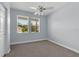 Bright bedroom with neutral carpet, two windows, and ceiling fan with lighting at 10151 Chorlton Cir, Orlando, FL 32832