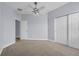 Cozy bedroom with neutral carpet, ceiling fan and light, and a double door closet at 10151 Chorlton Cir, Orlando, FL 32832