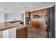 Cozy kitchen featuring wooden cabinetry, black appliances, tiled floor, and bar seating at 10151 Chorlton Cir, Orlando, FL 32832