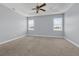 Spacious primary bedroom with tray ceiling, a ceiling fan, and light-filled windows at 10151 Chorlton Cir, Orlando, FL 32832