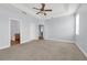 Bright primary bedroom with neutral walls and flooring, a fan, and access to a bathroom at 10151 Chorlton Cir, Orlando, FL 32832