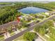 Aerial view of a townhome community with a pool, lake, and tennis court at 11081 Savannah Landing Cir, Orlando, FL 32832