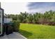 View of the backyard including a grassy lawn and landscaping features at 11081 Savannah Landing Cir, Orlando, FL 32832