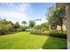 A view of the landscaped backyard including a lawn, trees, community features, and a paver patio at 11081 Savannah Landing Cir, Orlando, FL 32832