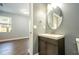 Bathroom with updated vanity, fixtures, and round mirror, and view to a bedroom with wood floors at 11081 Savannah Landing Cir, Orlando, FL 32832