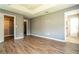 Large bedroom boasts tray ceiling, wood-look floors, and multiple closets and doorways at 11081 Savannah Landing Cir, Orlando, FL 32832