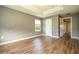 Bedroom with tray ceiling, wood-look floors, and a view to another room via a doorway at 11081 Savannah Landing Cir, Orlando, FL 32832