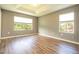 Spacious bedroom with tray ceiling, wood-look floors and great natural light from two large windows at 11081 Savannah Landing Cir, Orlando, FL 32832