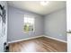 This is a bedroom with hardwood floors, gray walls, a mounted TV and a window at 11081 Savannah Landing Cir, Orlando, FL 32832