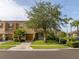 Inviting two-story townhome with well-kept lawn, brick paver driveway, and mature landscaping at 11081 Savannah Landing Cir, Orlando, FL 32832