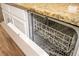 Open dishwasher with racks, revealing clean interior; white cabinets and granite countertops visible at 11081 Savannah Landing Cir, Orlando, FL 32832
