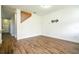 Spacious living room with wood-look vinyl flooring and neutral walls leading to a staircase at 11081 Savannah Landing Cir, Orlando, FL 32832