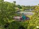 Community playground nestled among lush greenery, a lake, and community tennis and basketball courts at 11081 Savannah Landing Cir, Orlando, FL 32832