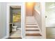 Staircase with wooden treads and view to the downstairs bathroom, featuring neutral paint and artwork at 11081 Savannah Landing Cir, Orlando, FL 32832