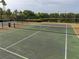 Well-maintained tennis court with a view of a nearby lake in the community at 11081 Savannah Landing Cir, Orlando, FL 32832